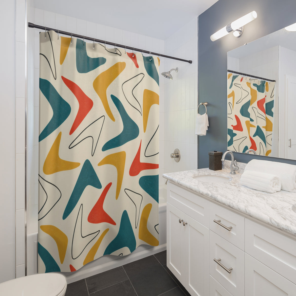 Teal, mustard and red boomerangs on ivory shower curtain beside a white vanity