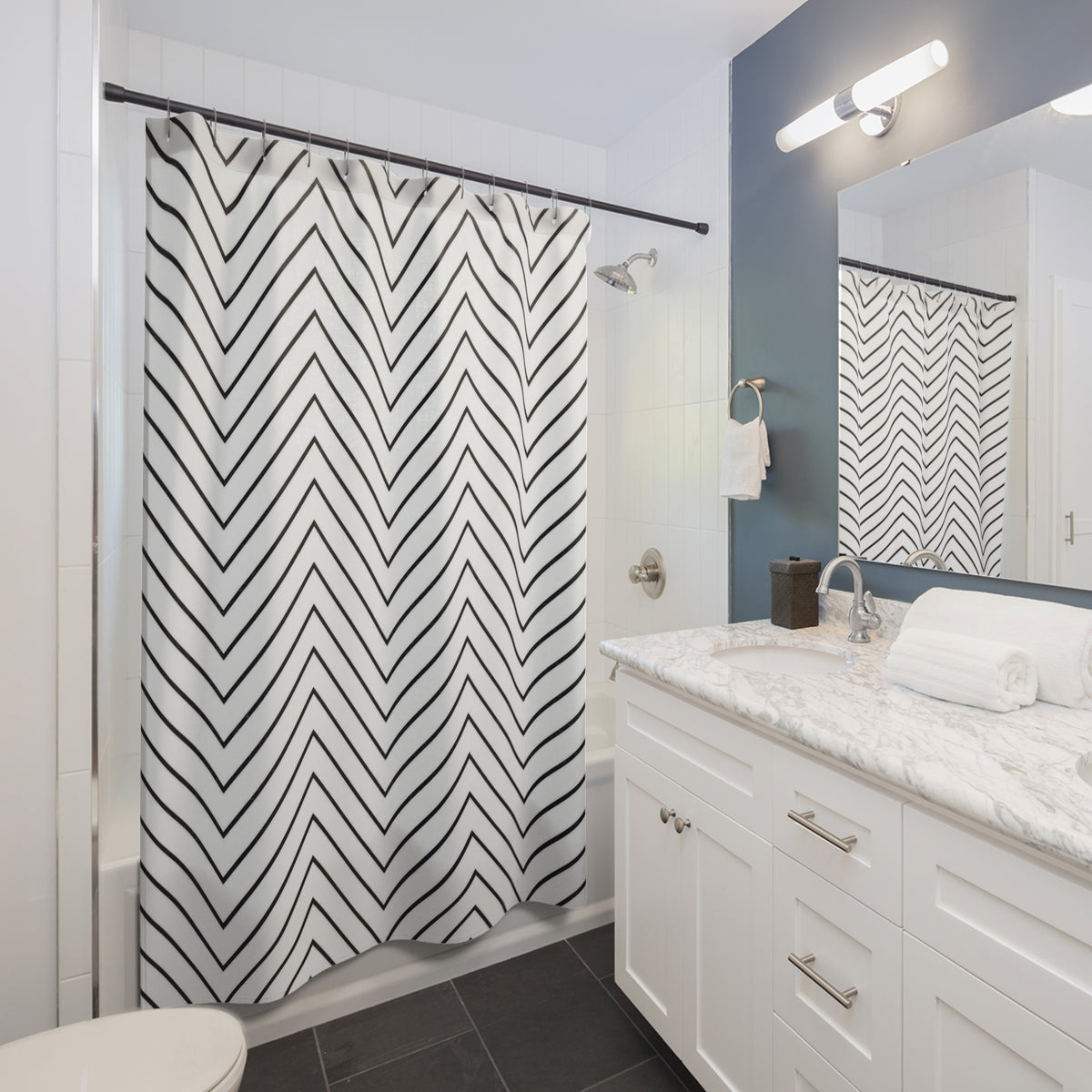 Thin black chevron zigzags on an open white ground shower curtain beside a white vanity