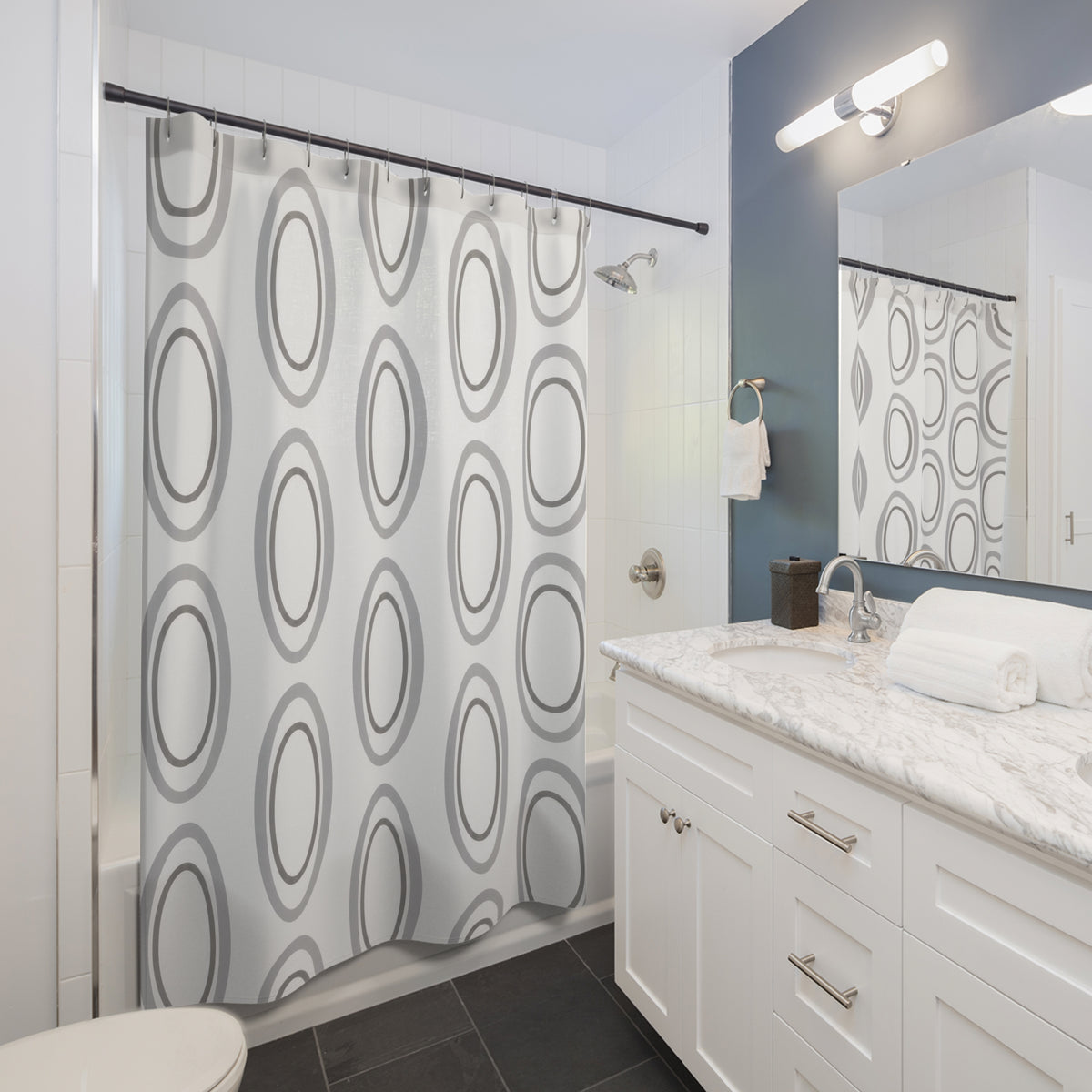 Silver gray nested ovals on white shower curtain beside a white vanity