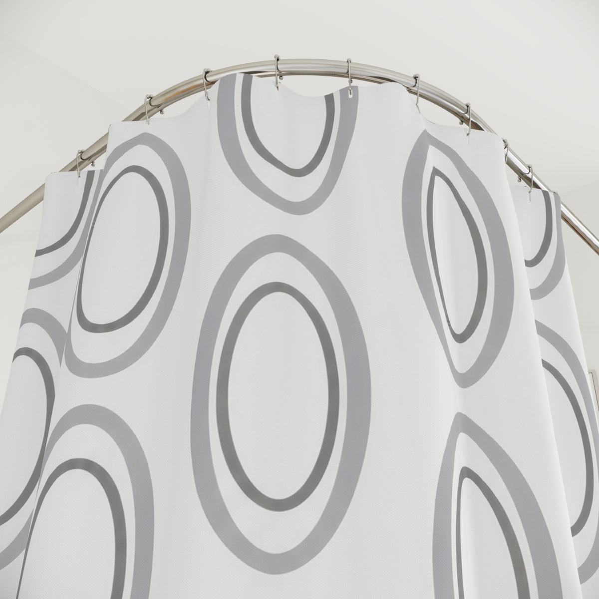 Silver gray nested ovals on white shower curtain with close-up print, hooks, and folds