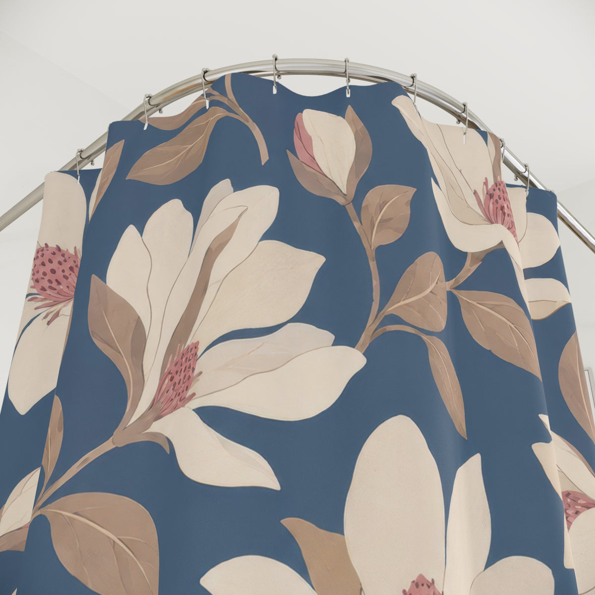 Cream and blush magnolia pattern on slate blue shower curtain with close-up print, hooks, and folds