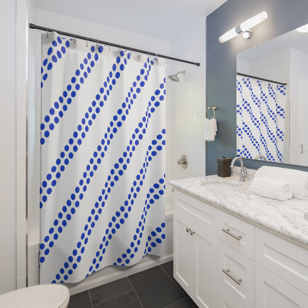 Paired diagonal cobalt dot stripes on white shower curtain beside a white vanity