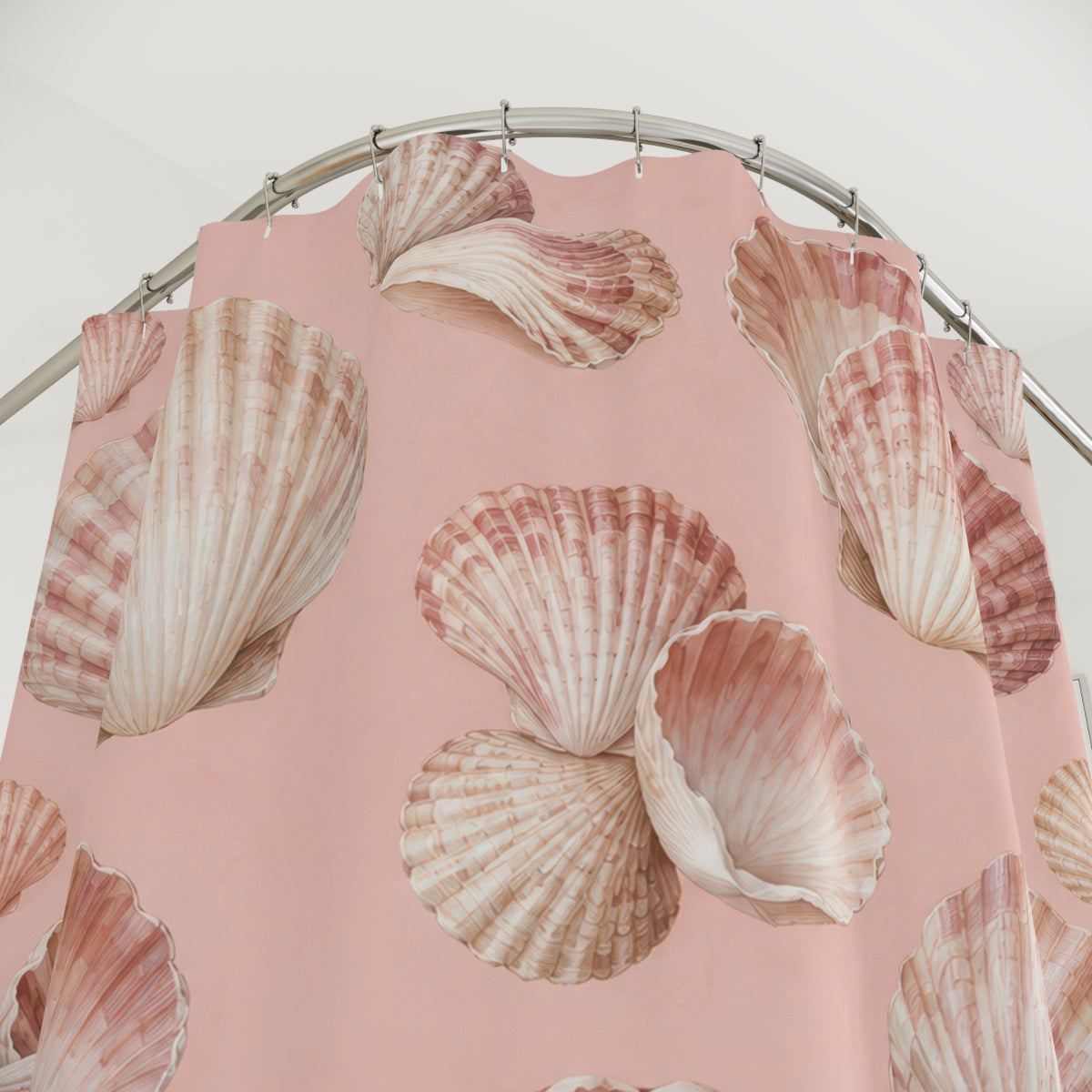 Ivory and rose seashells on blush pink shower curtain with close-up print, hooks, and folds