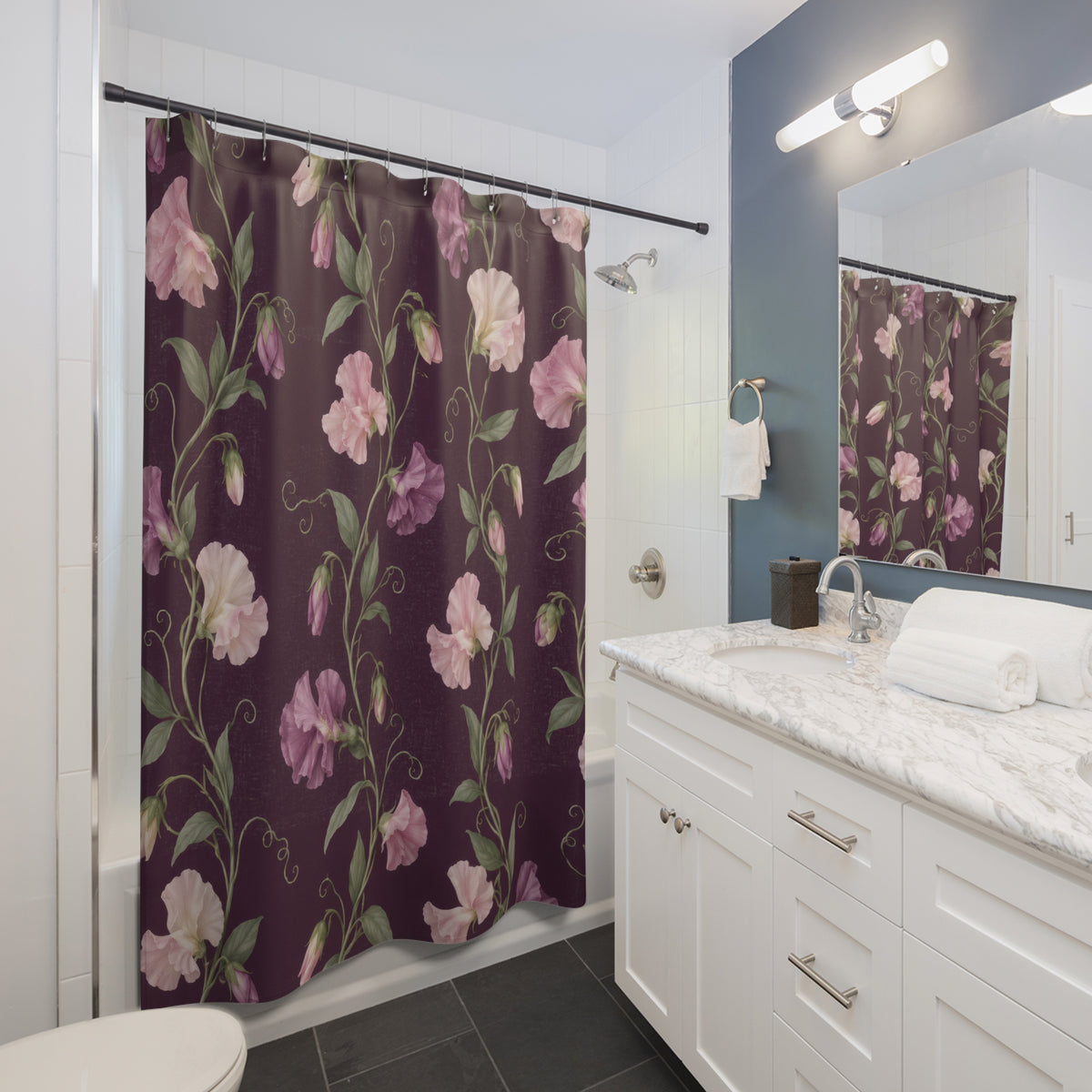 Pink sweet pea vines on plum with sage leaves shower curtain beside a white vanity