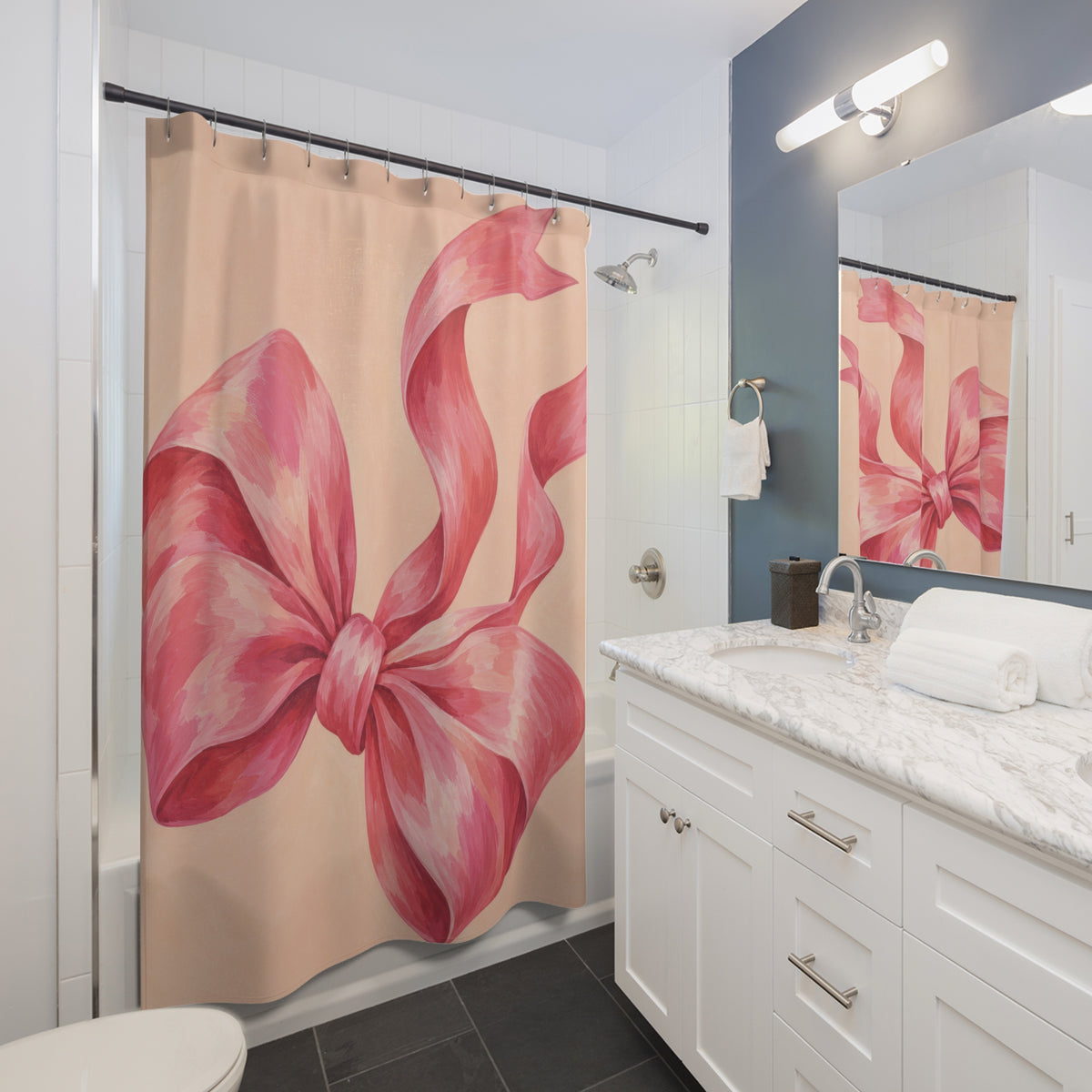 Oversized pink bow with curling tails on pale peach shower curtain beside a white vanity
