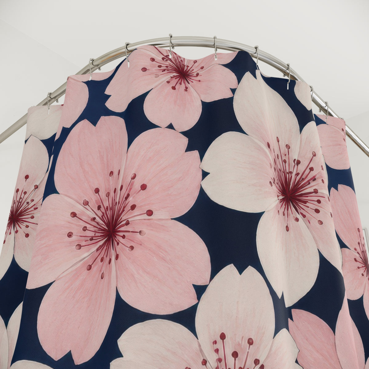 Pink and ivory cherry blossoms on navy shower curtain with close-up print, hooks, and folds