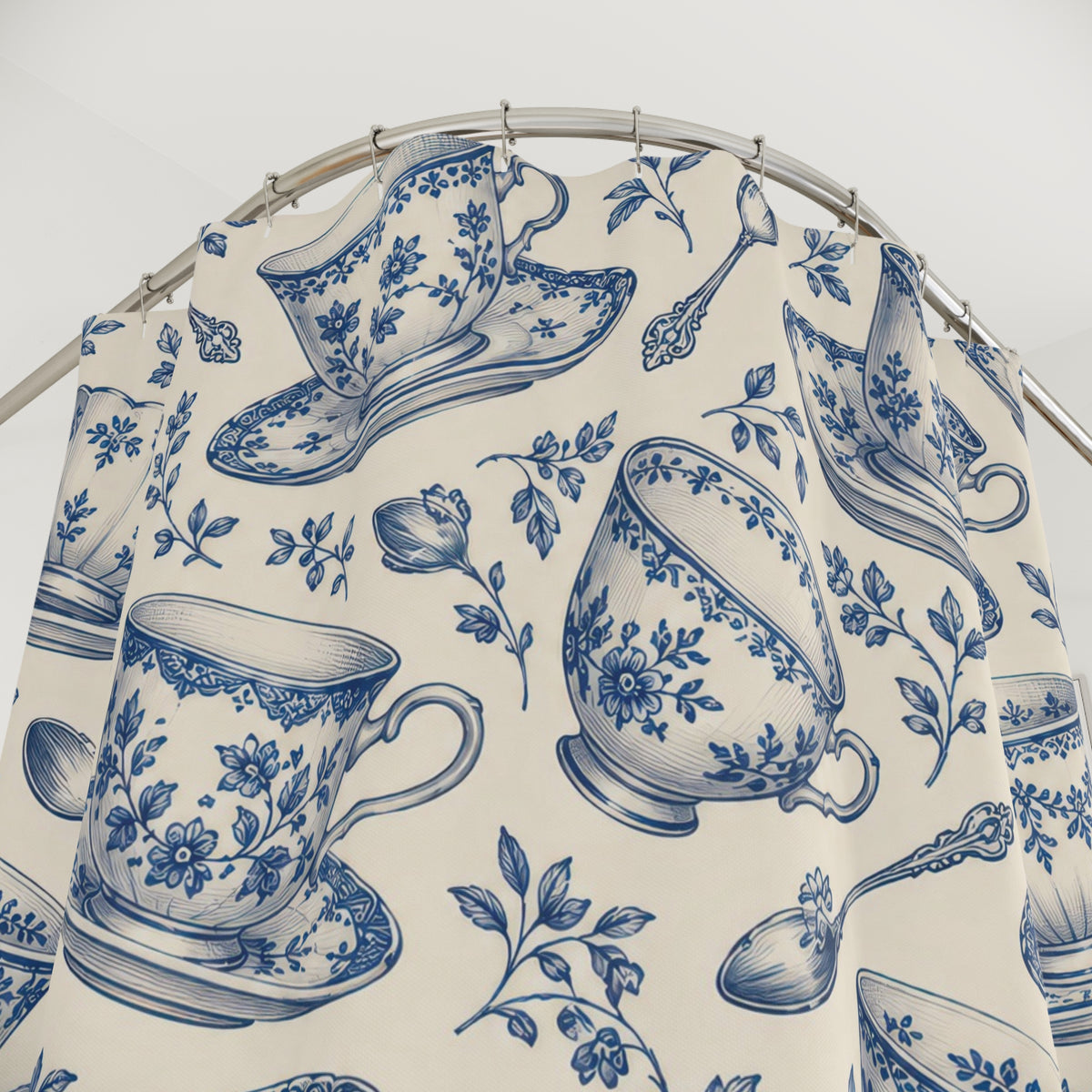Blue floral teacups and saucers on cream shower curtain with close-up print, hooks, and folds