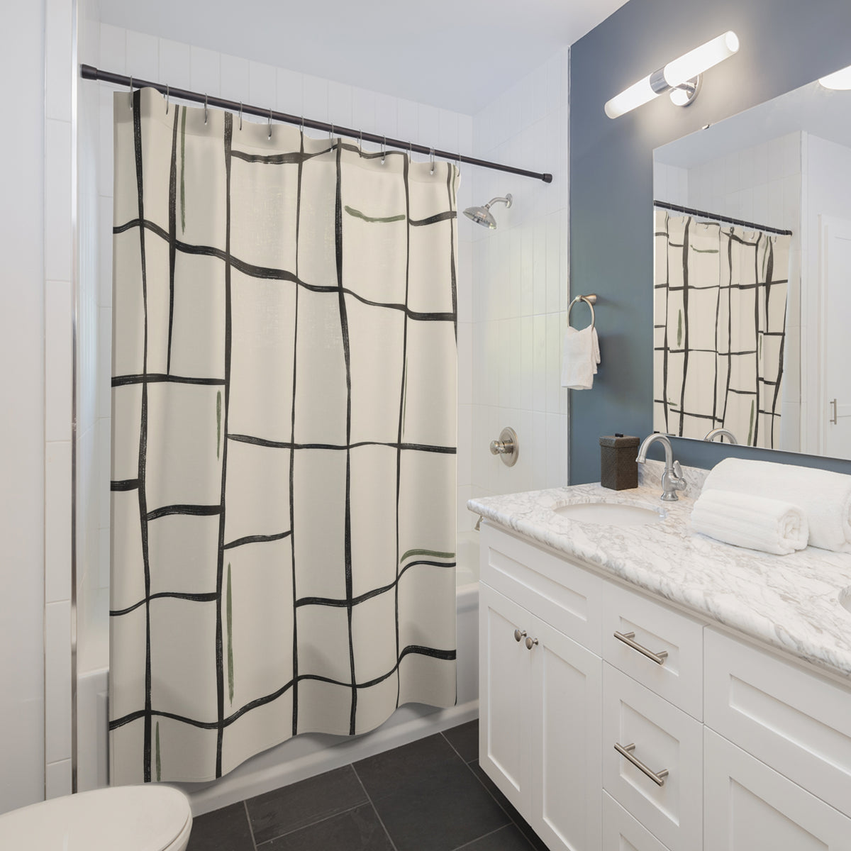 Charcoal irregular grid with sage strokes on ivory shower curtain beside a white vanity
