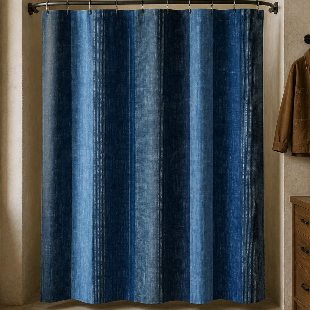 Navy denim stripe shower curtain in a workwear collector bathroom with oak drawers and tobacco coat