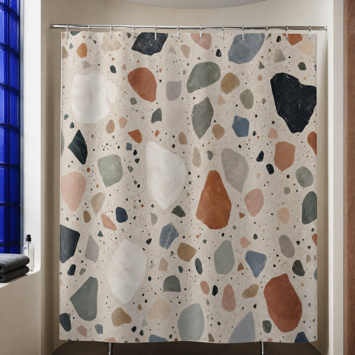 Multicolor stone chip shower curtain in a luxury curved plaster bathroom with cobalt glass lightwell and rust stone