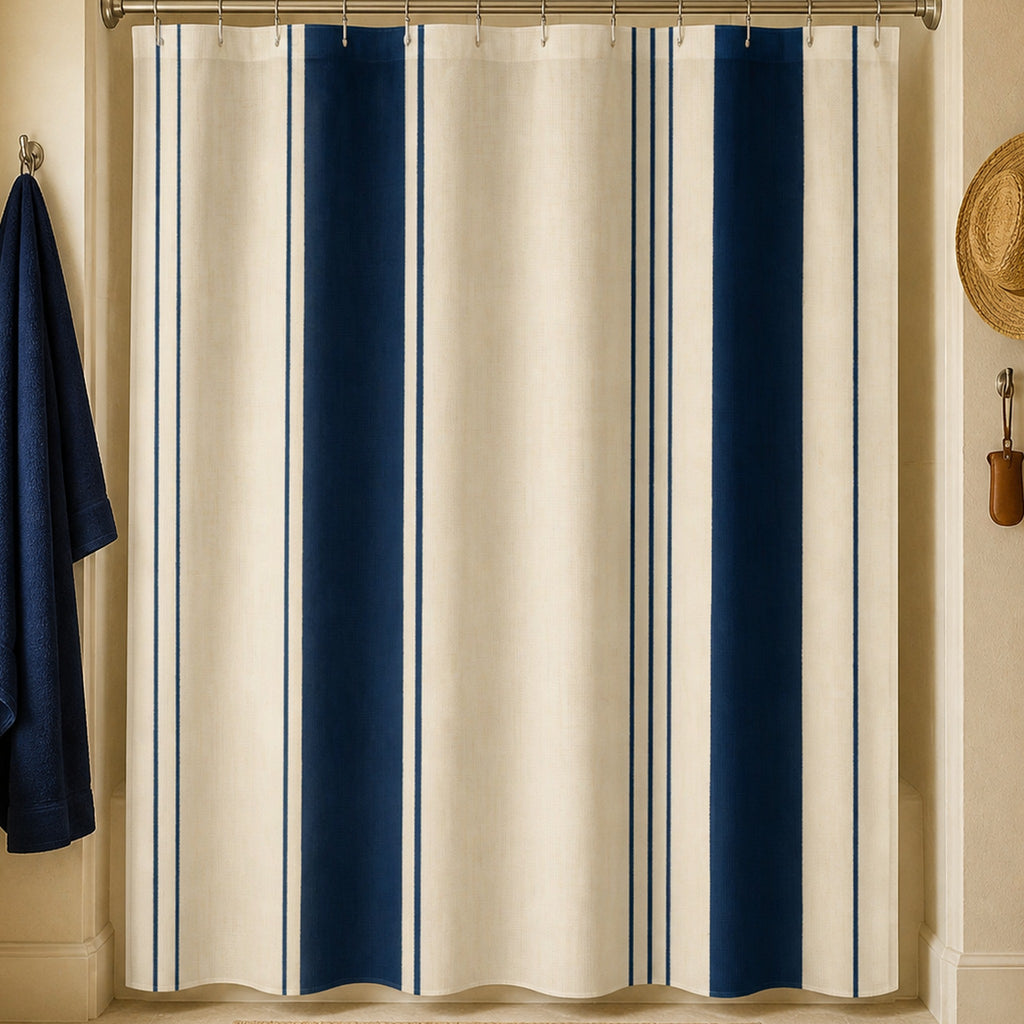 Navy cream pinstripe shower curtain in a coastal guesthouse bathroom with oak storage, navy robe and straw hat