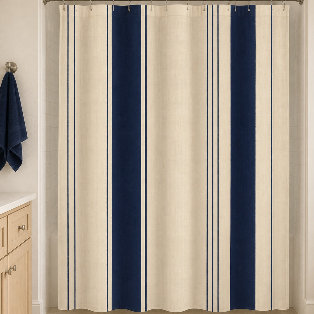 Navy cream pinstripe shower curtain in a warm white guest bathroom with maple vanity and navy towel