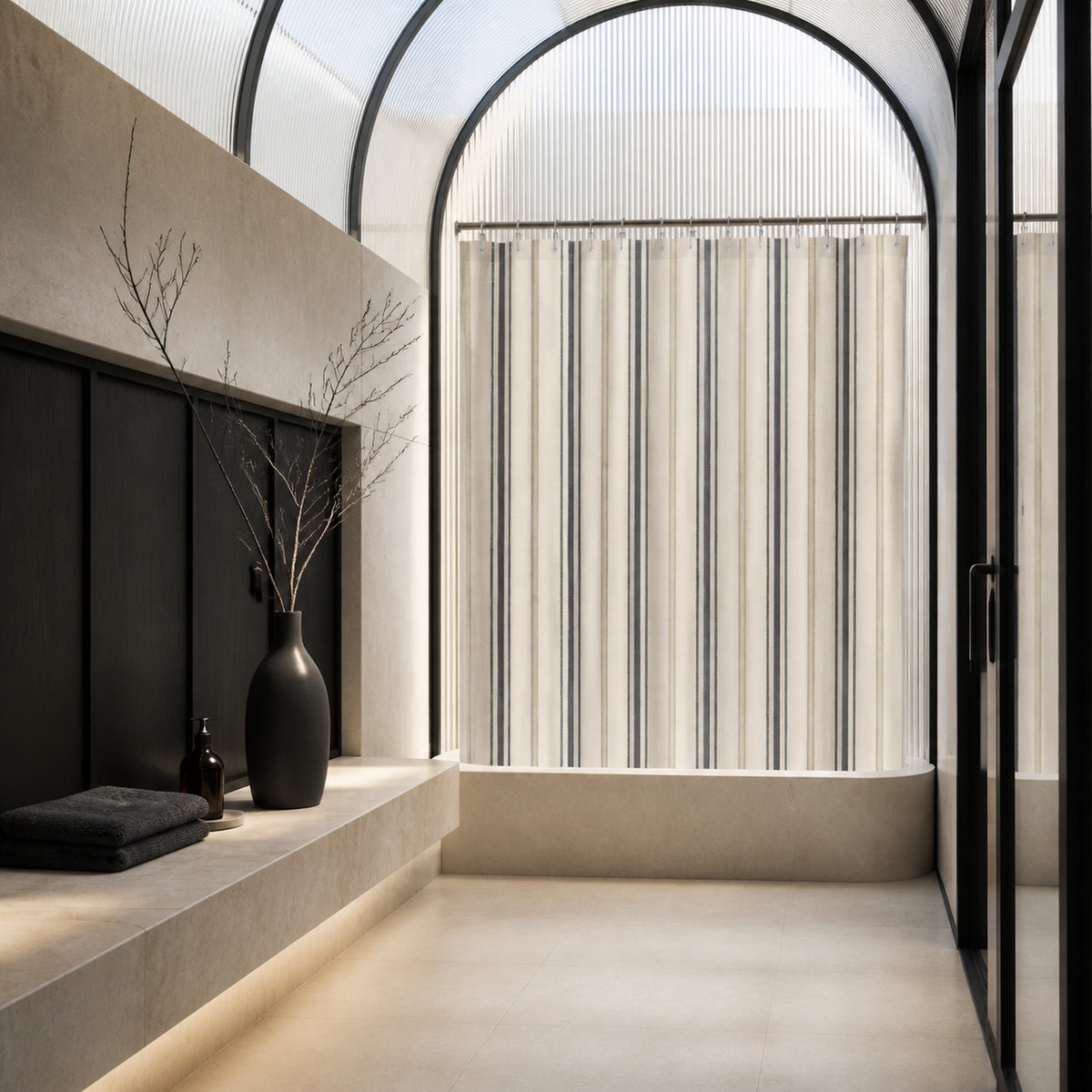 Charcoal and ivory ticking stripe shower curtain beneath a vaulted glass ceiling with limestone and black steel