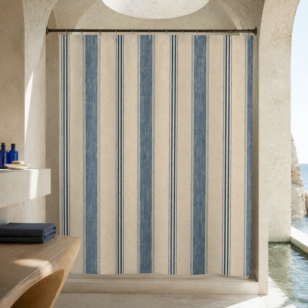 Weathered denim blue striped shower curtain in a vaulted limestone designer bathroom
