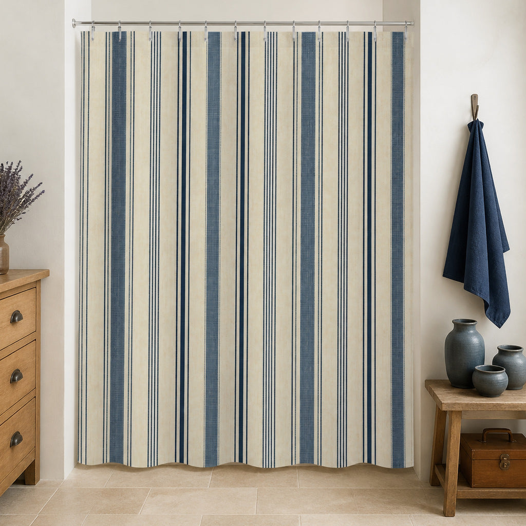 Indigo ivory ticking stripe shower curtain in a French country ceramicist washroom with honey pine and blue gray pottery